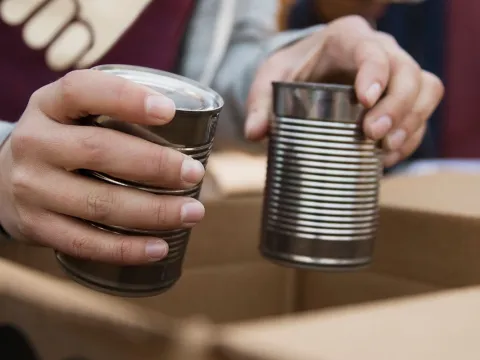 A food bank volunteer puts canned food into a box