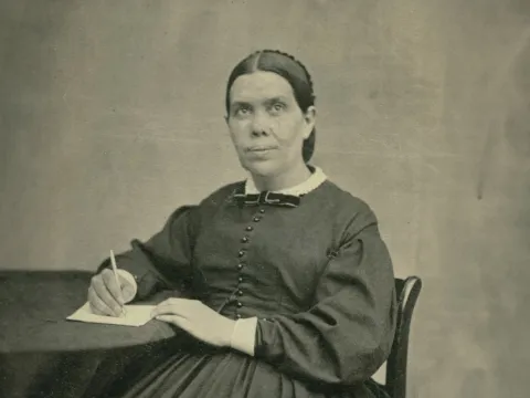 Ellen White writing at a table.