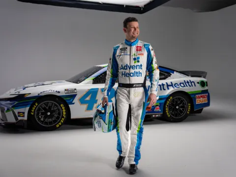 Erik Jones stands in front of his NASCAR vehicle.