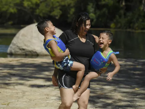 Mother playing with her two sons on the shore.