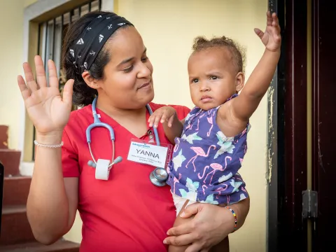 Doctor holding child on a mission trip.