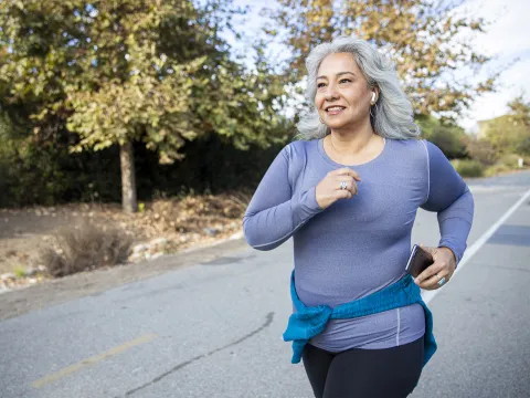 Older woman running along a road
