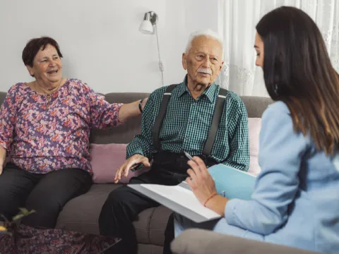 caregiver with eldery couple at home