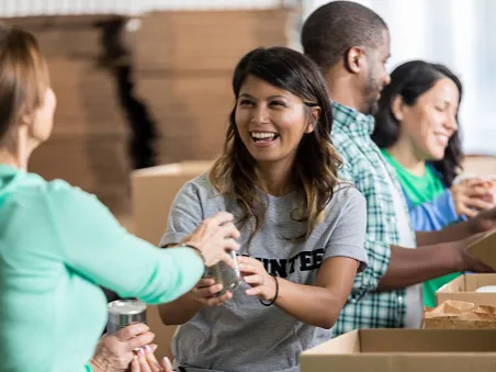 women giving woman glass while packing