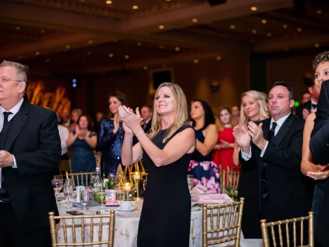 A group of people clapping at a gala night.