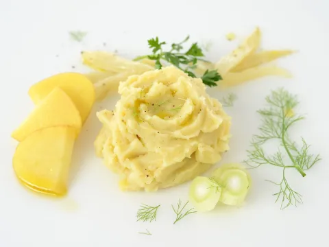 a pile of mashed fennel and mashed potatoes, with sliced potatoes on the side