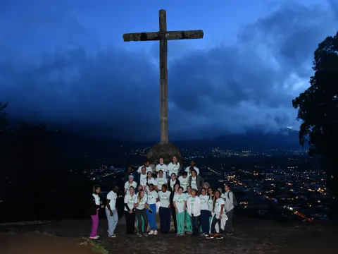 The group of AdventHealth volunteers gather in front of a cross above the city of Antigua, Guatemala.