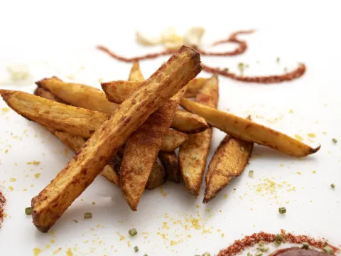 Small pile of French fries on a white counter.