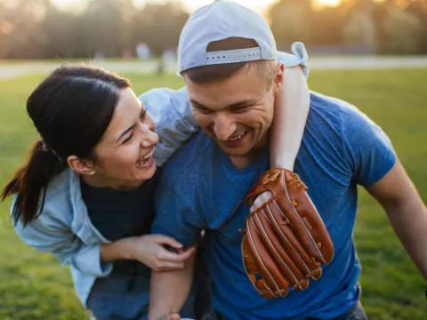 A woman and a man hugging on a baseball field.