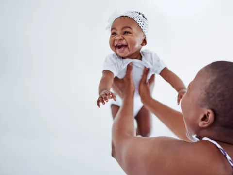 Mother holding up her baby.