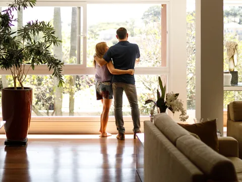 A couple hugging and looking out a window.