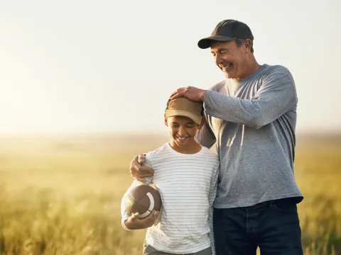 A father hugs his son after a game of football