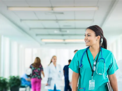 Female health care professional walking down hospital hallway