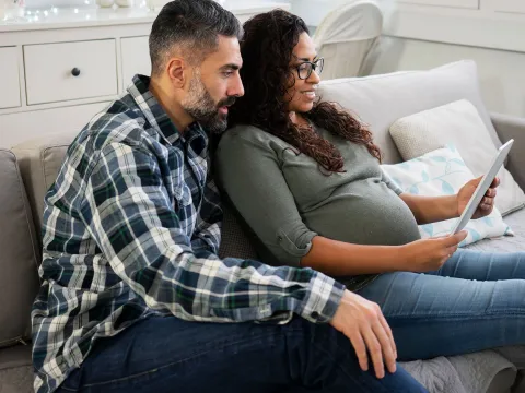 An expecting couple doing a video chat.