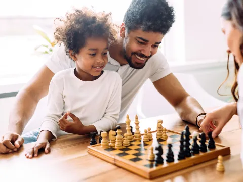 A family playing chess together. 