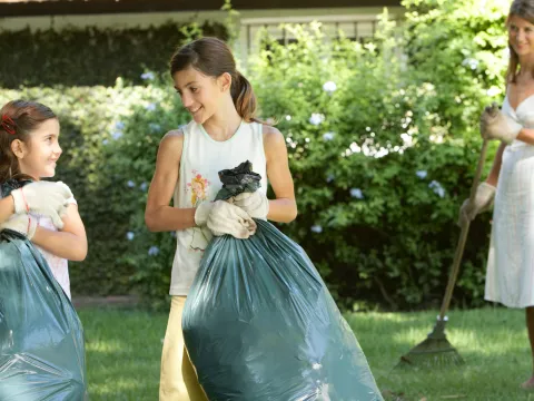 A family cleans up the lawn together.