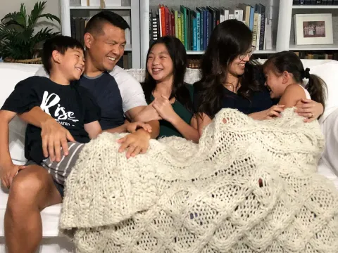 Family laughing on couch