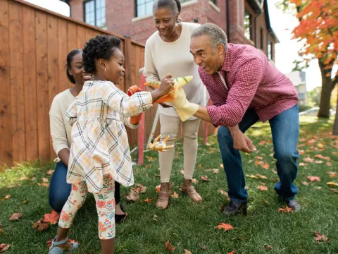 A family plays in the backyard during the fall.