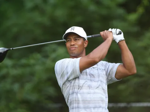 Golfer, Tiger Woods, watches his ball fly after swinging his golf club