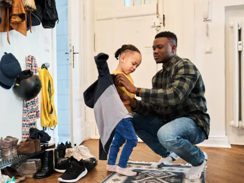 Father and daughter getting ready to go outside from their house