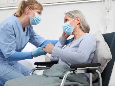 A caregiver comforts a patient. 