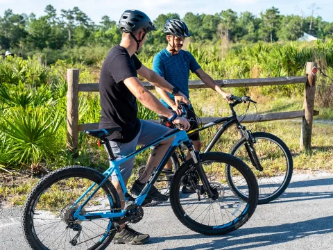 Two men standing beside their bikes