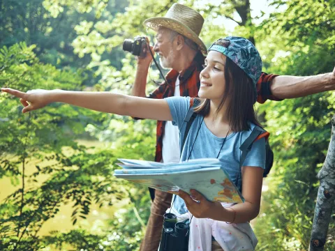 A grandfather hiking with his granddaughter. 