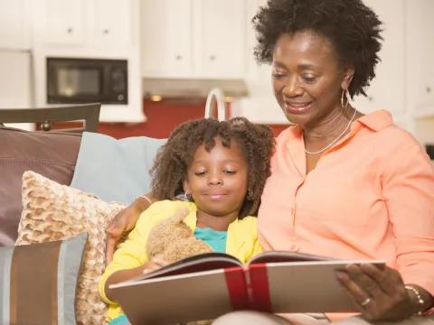 A woman reading to a child in the living room. 