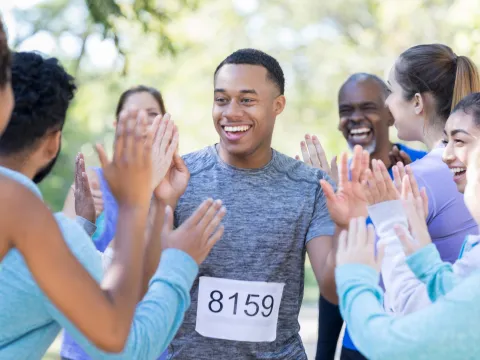 A happy runners gets a high five after finishing a race.