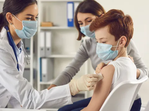 A young boy getting ready to receive a vaccine shot