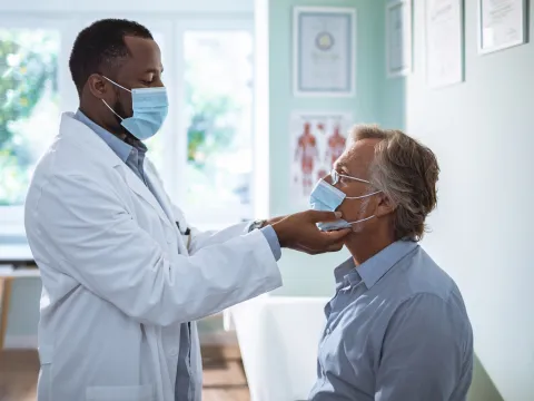 A male doctor examining a male patient. 