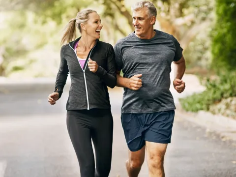 A couple goes for a run together in the Fall.