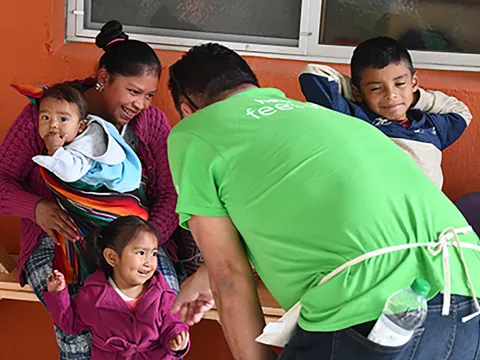 An AdventHealth team member greets a Guatemala family outside a malnutrition center in San Juan, Guatemala.