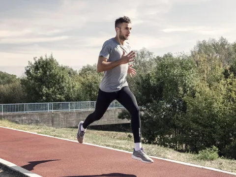 A man running outdoors on a track.