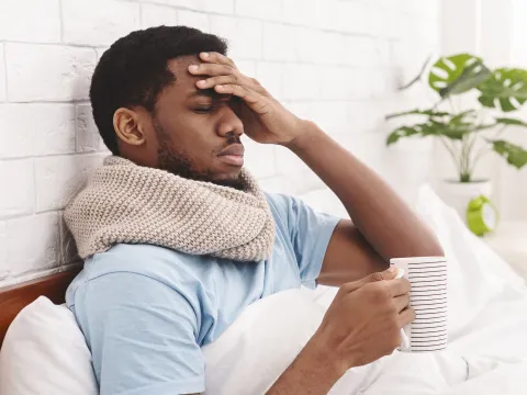 A man feeling under the weather in bed.