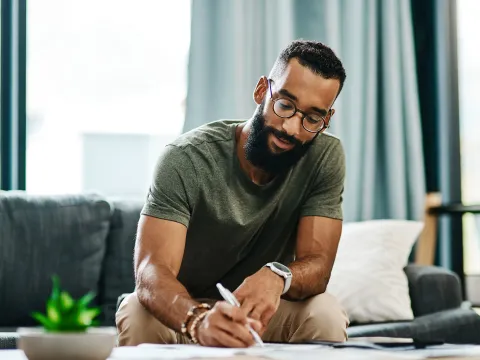 A man writes a list at home while he's quarantined