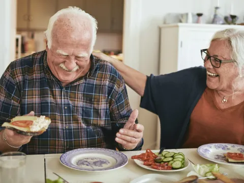 A couple enjoys a meal while laughing about their day.