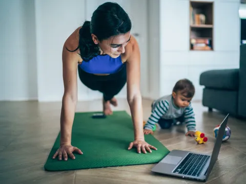 A mom exercising at home with her baby. 