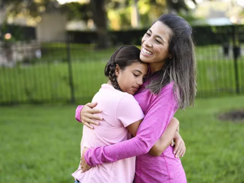 A mother and daughter hugging. 