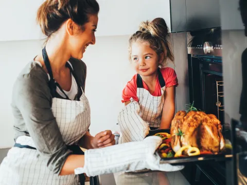 A mom prepares a healthy turkey recipe for Thanksgiving with her daughter.