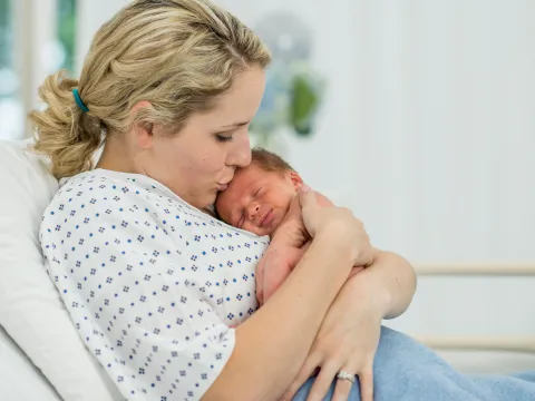 A mother holds her new baby in the hospital.