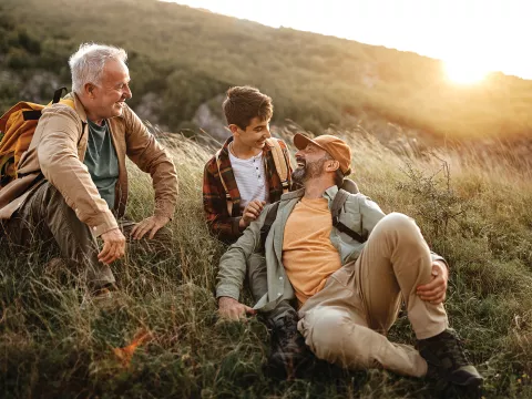 A grandfather, father, and son hiking