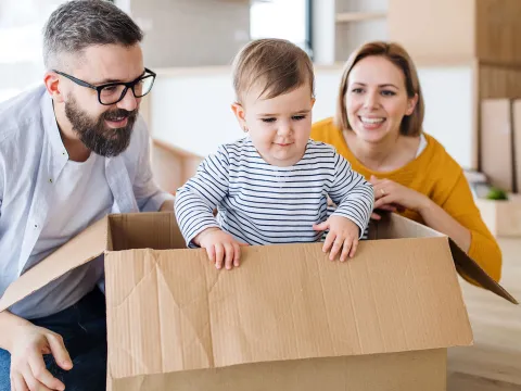 A baby playing in a cardboard box.