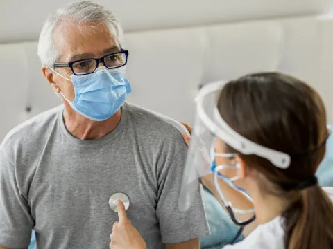 A doctor using a stethoscope on a patient