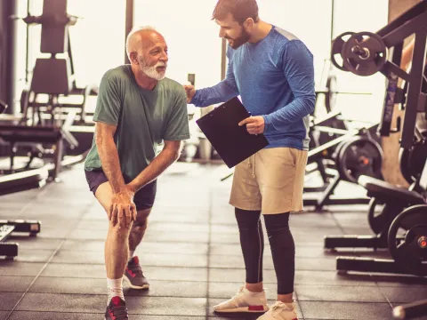 An older man works with a physical therapist.