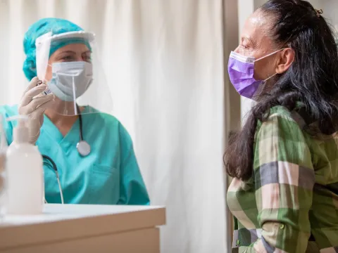 A woman visiting her provider for a flu shot. 