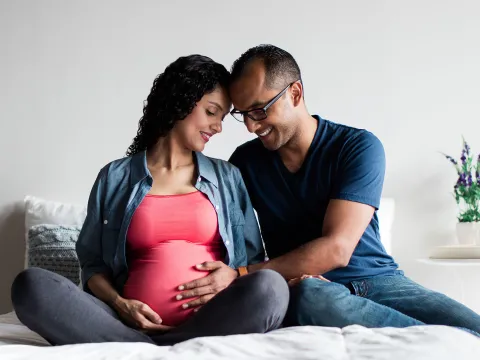 A pregnant couple at home.