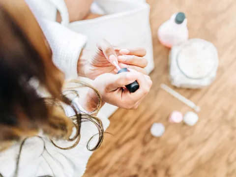 A woman takes some time for self care by painting her nails.