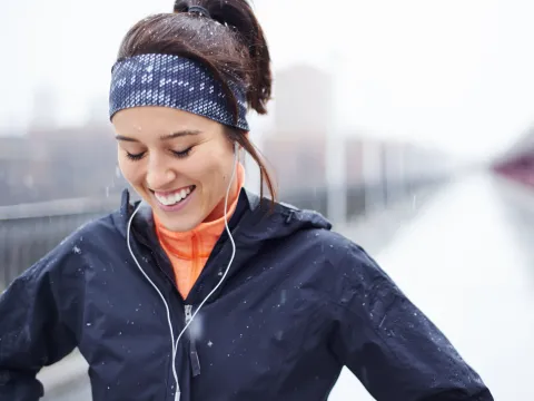 A woman runs in cold, wet weather.