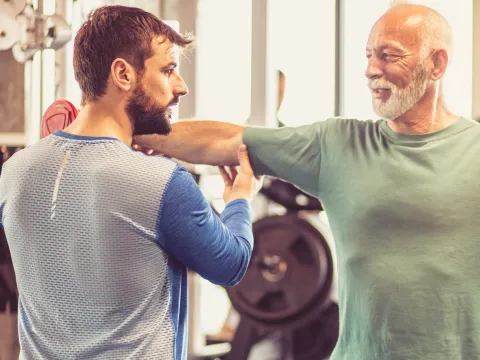 Trainer helping a person perform exercises